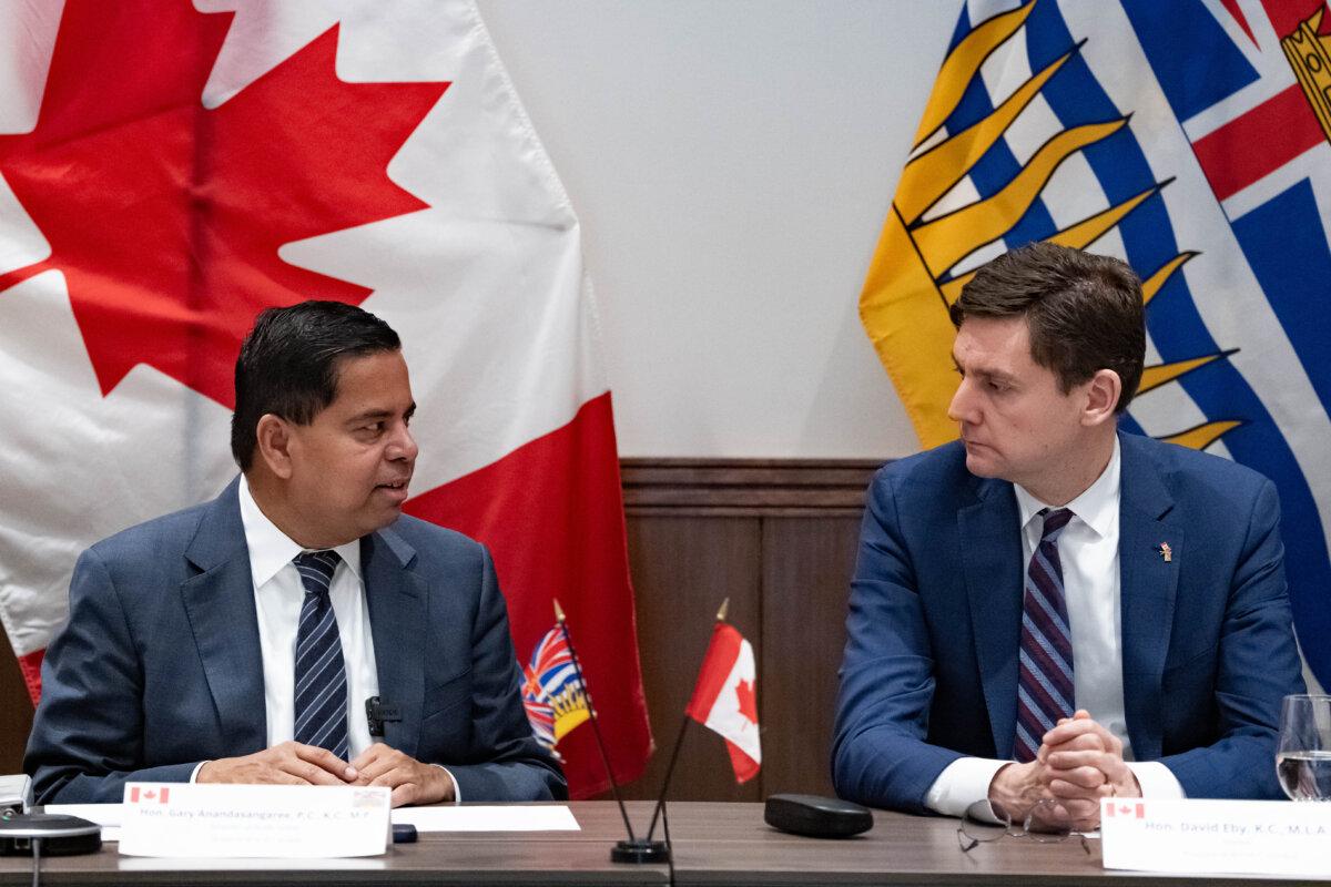 Federal Minister of Public Safety Gary Anandasangaree (L) speaks with B.C. Premier David Eby during a meeting on new funding to support victims of crime, in Surrey, B.C., on Nov. 28, 2025. (The Canadian Press/Ethan Cairns)