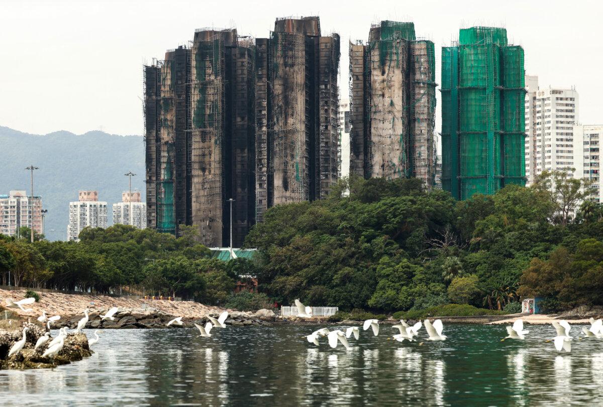 Birds fly next to burned buildings of the Wang Fuk Court housing complex after the deadly fire in Tai Po, Hong Kong, on Nov.30, 2025. (Maxim Shemetov/Reuters)