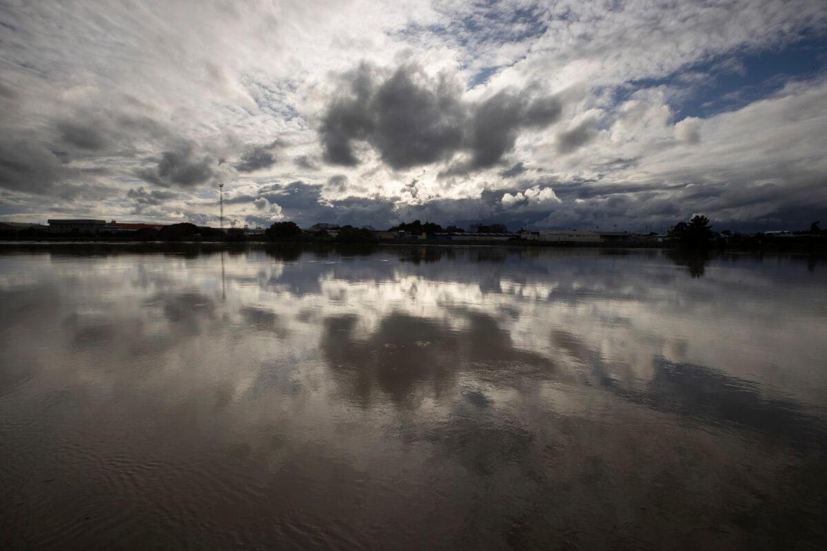 Clouds are reflected in the Whanganui River in the town of Whanganui, New Zealand, on June 17, 2022. (AP Photo/Brett Phibbs)
