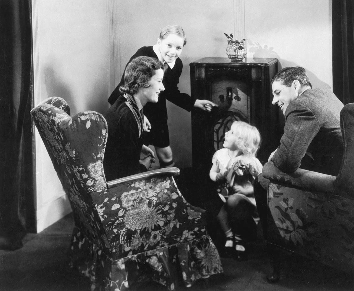 A family gathers around the radio to listen to a program, circa 1935. (FPG/Hulton Archive/Getty Images)