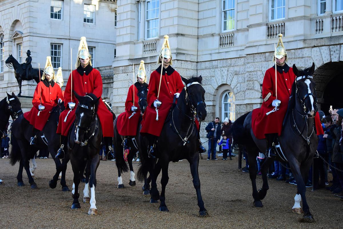 The Household Cavalry Mounted regiment performs ceremonial duties at Buckingham Palace. Troopers wear traditional uniforms featuring metal cuirasses and plumed helmets. (Luke Ow/Unsplash)