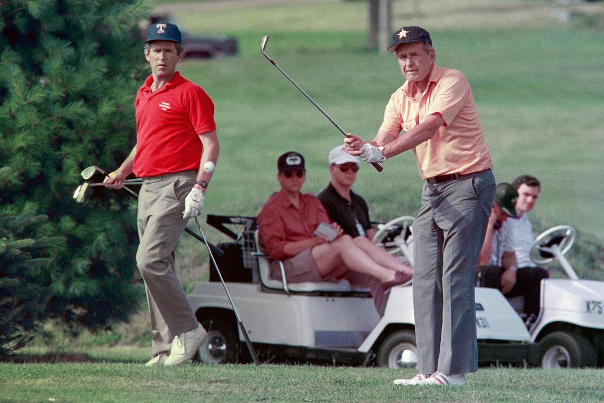 President George H.W. Bush (R) plays golf with his son, George W. Bush (L), at Cape Arundel Golf Course in Kennebunkport, Maine, on Aug. 19, 1989. (GREG GIBSON/Getty Images)