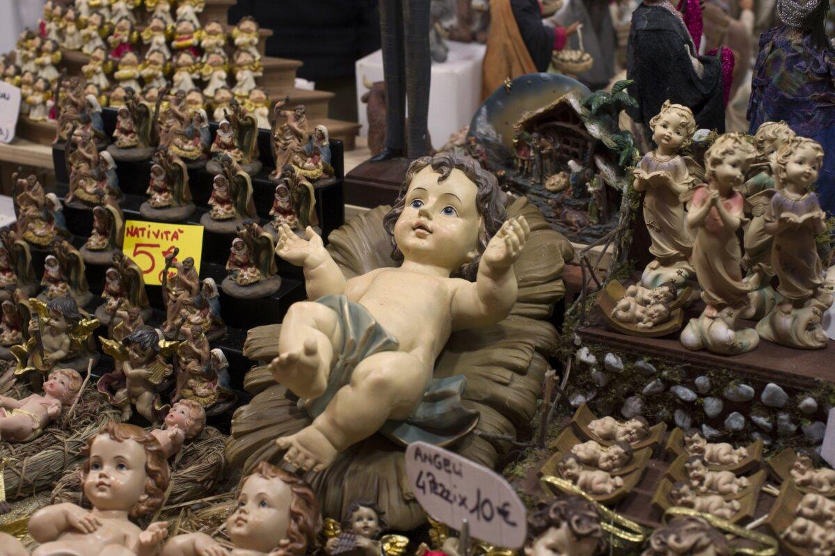 A large Christ Child figurine is surrounded by other crèche figurines on a market stall in Duomo Square, Milan. (Paolo Bona/Shutterstock)