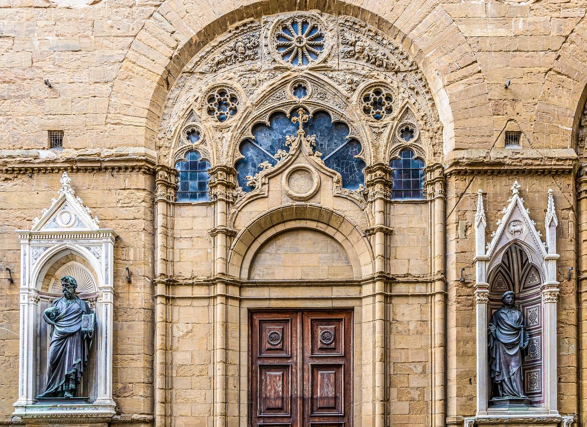 In 1367, the loggia’s archways were closed up and reconstructed with elegant mullioned windows during its conversion from a market to a church. Each of the main guilds was assigned a space between the arches to make a framed niche, featuring its patron saint. Standing more than eight feet tall, statue replications of Lorenzo Ghiberti’s St. Matthew (L) and St. Stephen are among Orsanmichele’s 14 exterior sculptures that decorate the building's façade. (Alex_Mastro/Shutterstock)