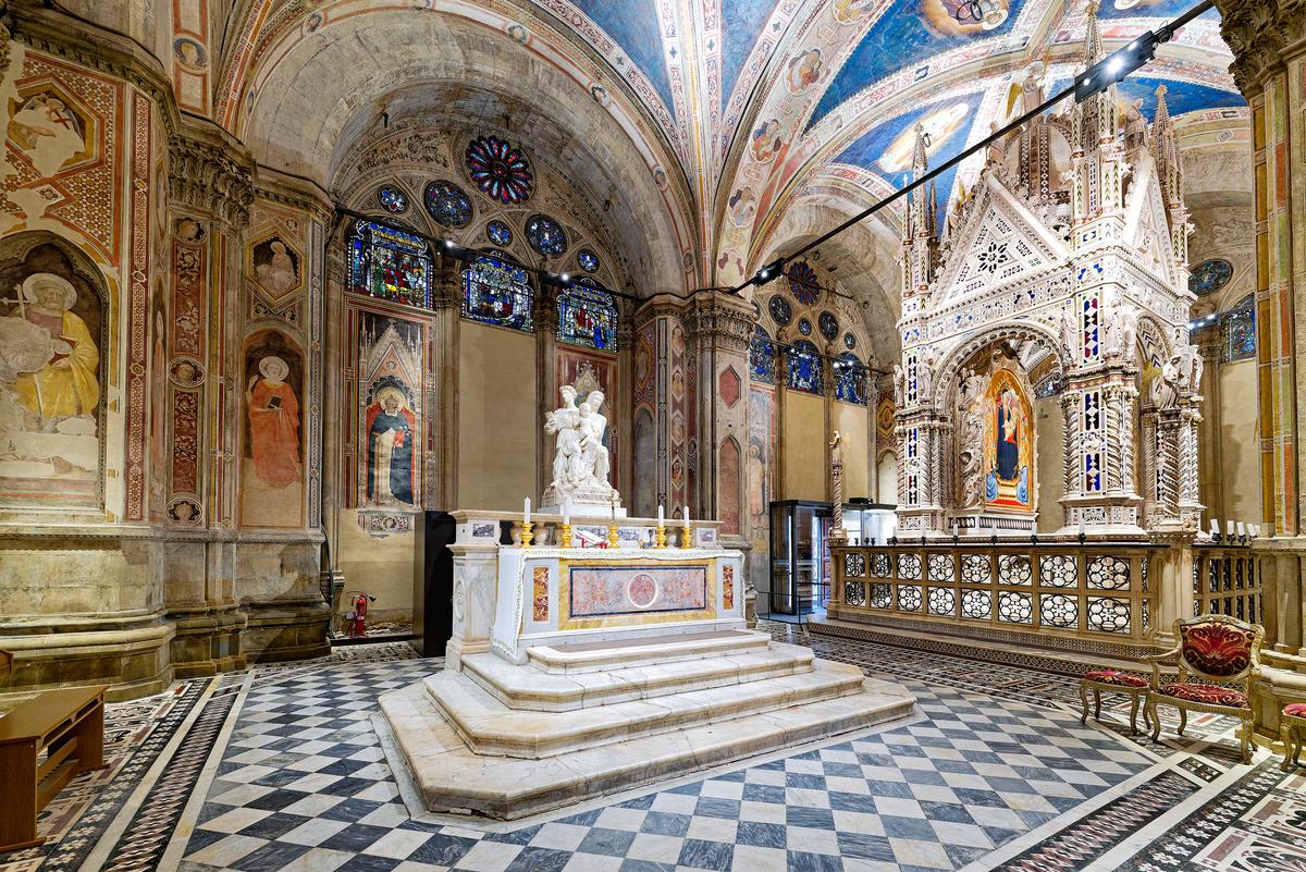 Saint Anne, mother of the Virgin Mary and <a href="https://guidaturistica-michelebusillo.com/the-fascinating-story-of-orsanmichele-church-florence/" target="_blank" rel="nofollow noopener">patron saint</a> of Florence, is honored in Orsanmichele’s side chapel. On the altar is a sculpture of Anne, Mary, and the infant Jesus by Francesco da Sangallo—one of the building’s few High Renaissance artworks. The side chapel, which was originally the interior market, is just as large as the main chapel to the right. (MB_Photographer/Shutterstock)