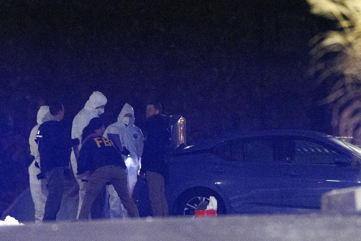 Investigators look at a grey Nissan car at a storage facility where the Brown University shooter, identified by authorities as Claudio Neves Valente, took his own life, in Salem, N.H., on Dec. 18, 2025. (CJ Gunther/Reuters)