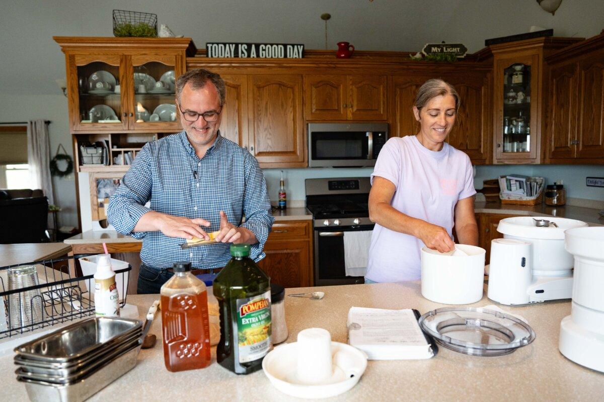 Owner of Timbercrest Farm Bakery, Marcus Wengerd, takes out the butter while his wife, Rebecca Wengerd, prepares to bake bread at their home in Trail, Ohio, on May 27, 2025. (Samira Bouaou/The Epoch Times)