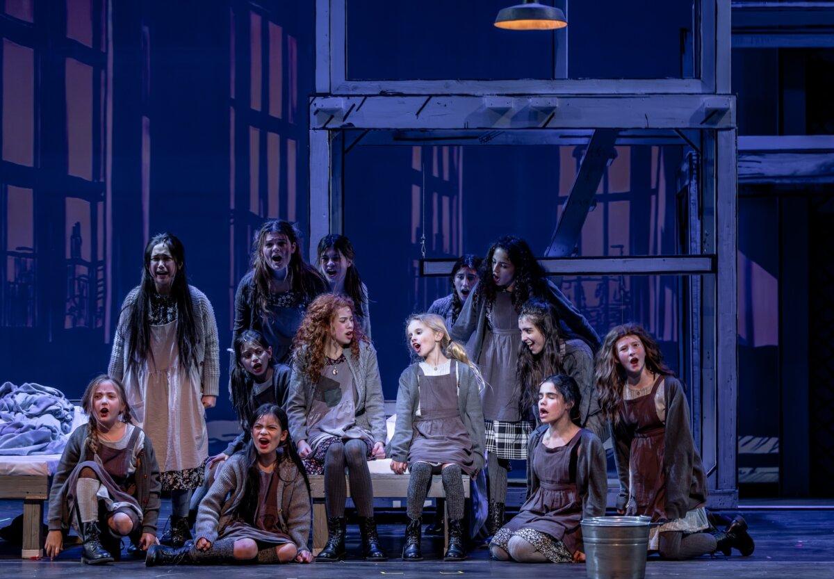 (C) Annie (Elin Joy Seiler) and Molly (Audrey Bucholz) surrounded by the other orphans in the Skokie, Ill., production of “Annie.” (Brett Beiner)
