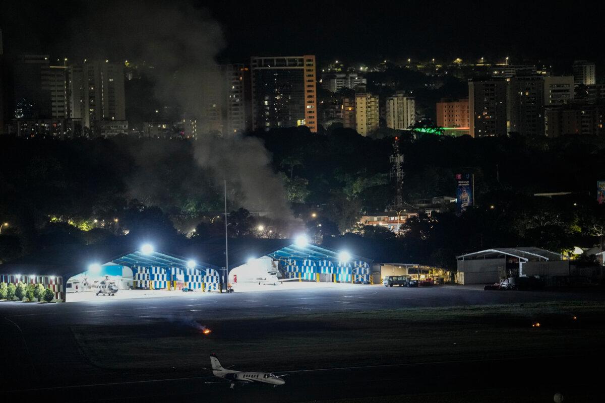 Smoke rises at La Carlota airport after explosions and low-flying aircraft were heard in Caracas, Venezuela, on Jan. 3, 2026. (AP Photo/Matias Delacroix)