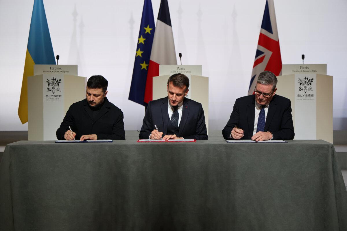 Ukrainian President Volodymyr Zelenskyy (L), French President Emmanuel Macron (C), and British Prime Minister Keir Starmer (R) sign a declaration on deploying a post cease-fire force in Ukraine, at the Elysee Palace in Paris, on Jan 6, 2026. (Ludovic Marin, Pool photo via AP)