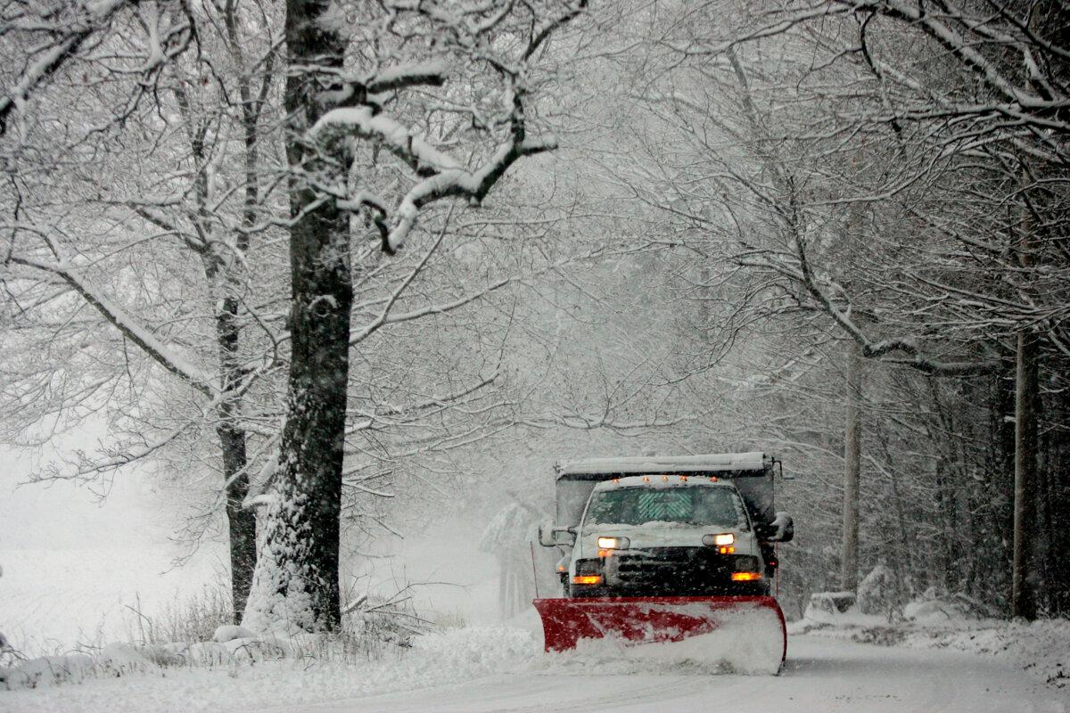 A snow plow clears the road of snow near Lincoln, Mass., on Dec. 9, 2005. (Joe Raedle/Getty Images)