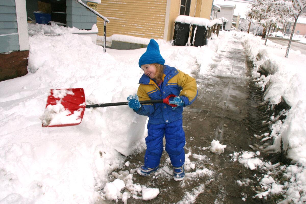 A girl removes snow from her family's driveway in Burlington, Vt., on Nov. 18, 2002. (Jordan Silverman/Getty Images)