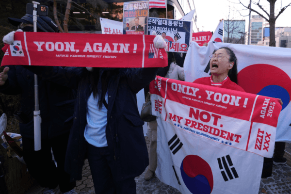 Supporters of former South Korean President Yoon Suk Yeol hold signs outside of Seoul Central District Court, in Seoul, South Korea, on Jan. 13, 2026. (Lee Jin-man/AP Photo)