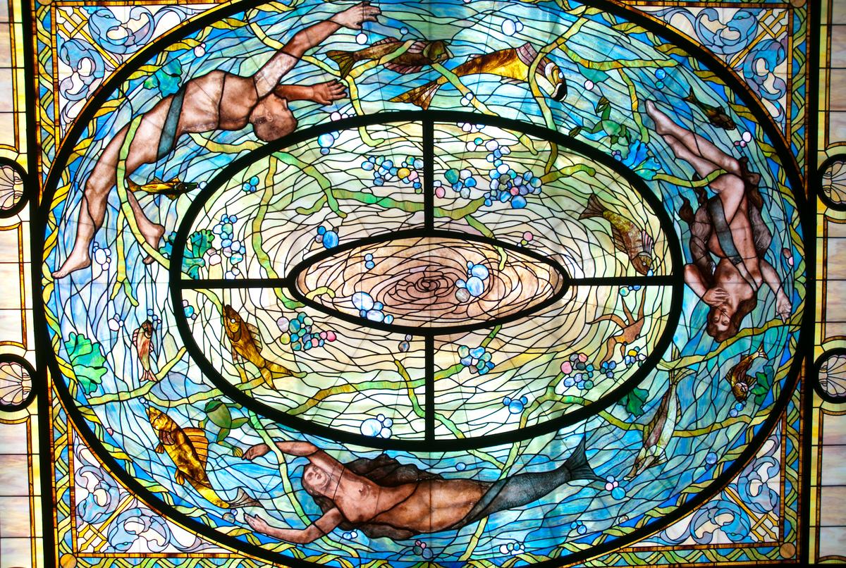 The Men’s Bath Hall's most stunning feature is its 8,000-piece, art-glass ceiling displaying an elaborate underwater scene that represents Neptune's daughter, mermaids, and sea creatures. The colorful glass was designed to convey movement, as if all the elements were in a swirl of water. (Zack Frank/Shutterstock)