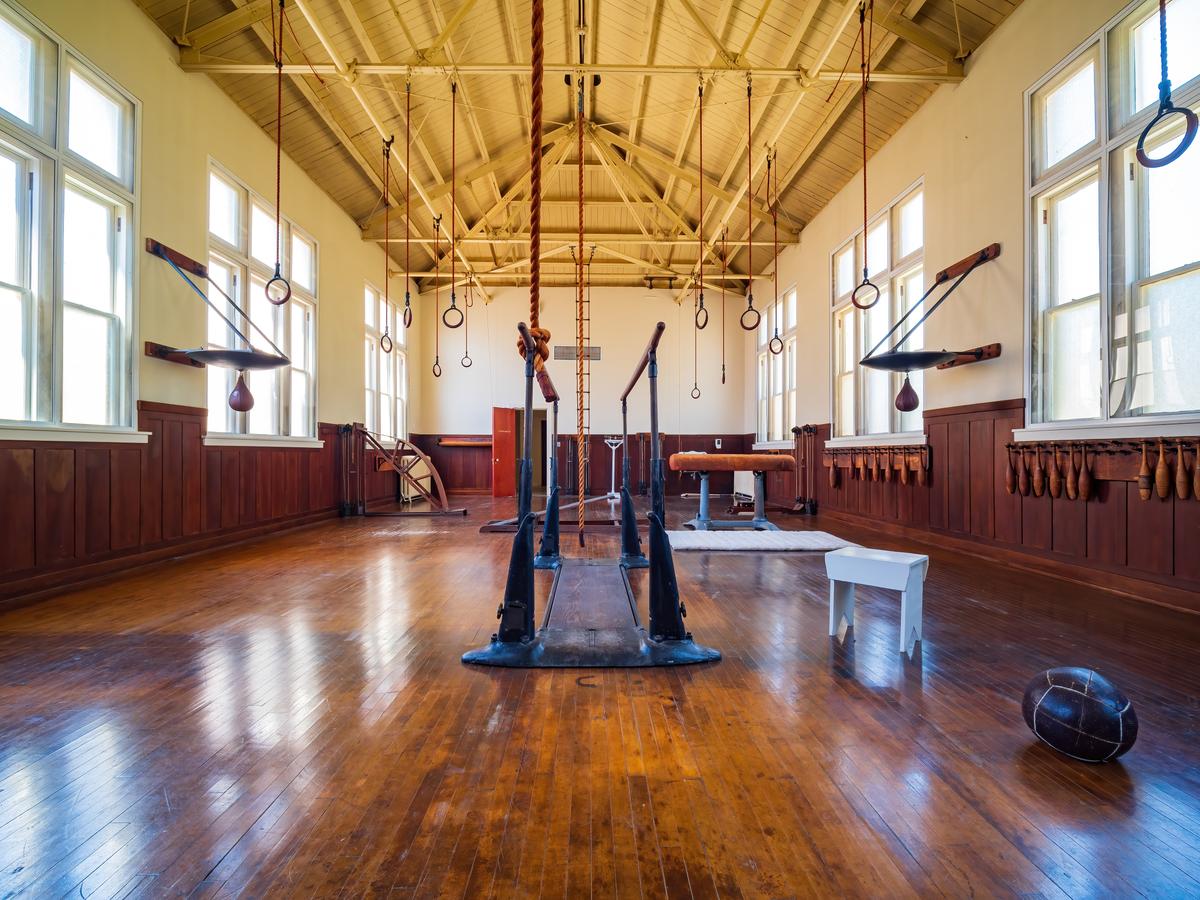 When Fordyce was constructed in 1915, its third-floor gymnasium was considered the largest and best equipped in Arkansas. From an exposed, vaulted metal ceiling hang exercise rings; the room’s flooring is sanded and varnished maple. (Kit Leong/Shutterstock)
