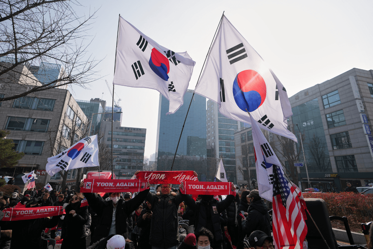 Supporters of former South Korean President Yoon Suk Yeol hold signs and flags outside Seoul Central District Court, in Seoul, South Korea, on Jan. 16, 2026. (Lee Jin-man/AP Photo)