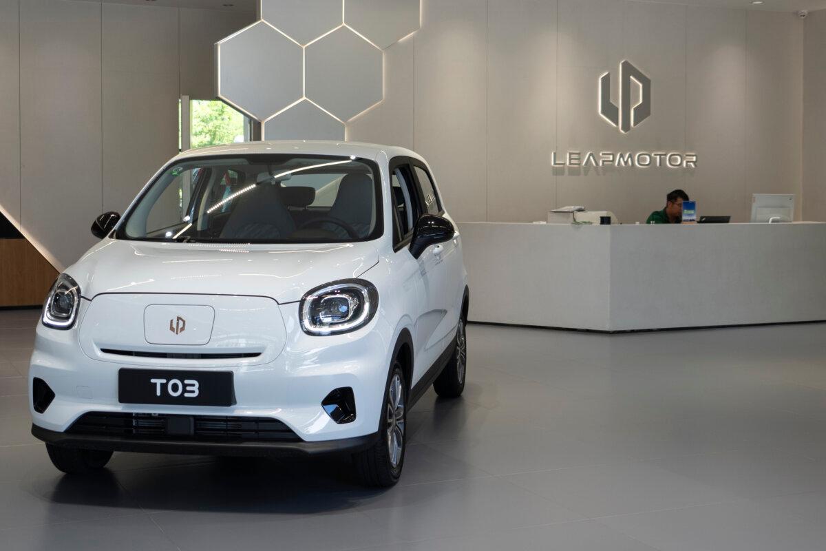 A receptionist sits near the Leapmotor T03 model displayed at a showroom in Hangzhou in eastern China's Zhejiang province on Tuesday, May 14, 2024. (Caroline Chen/AP Photo)