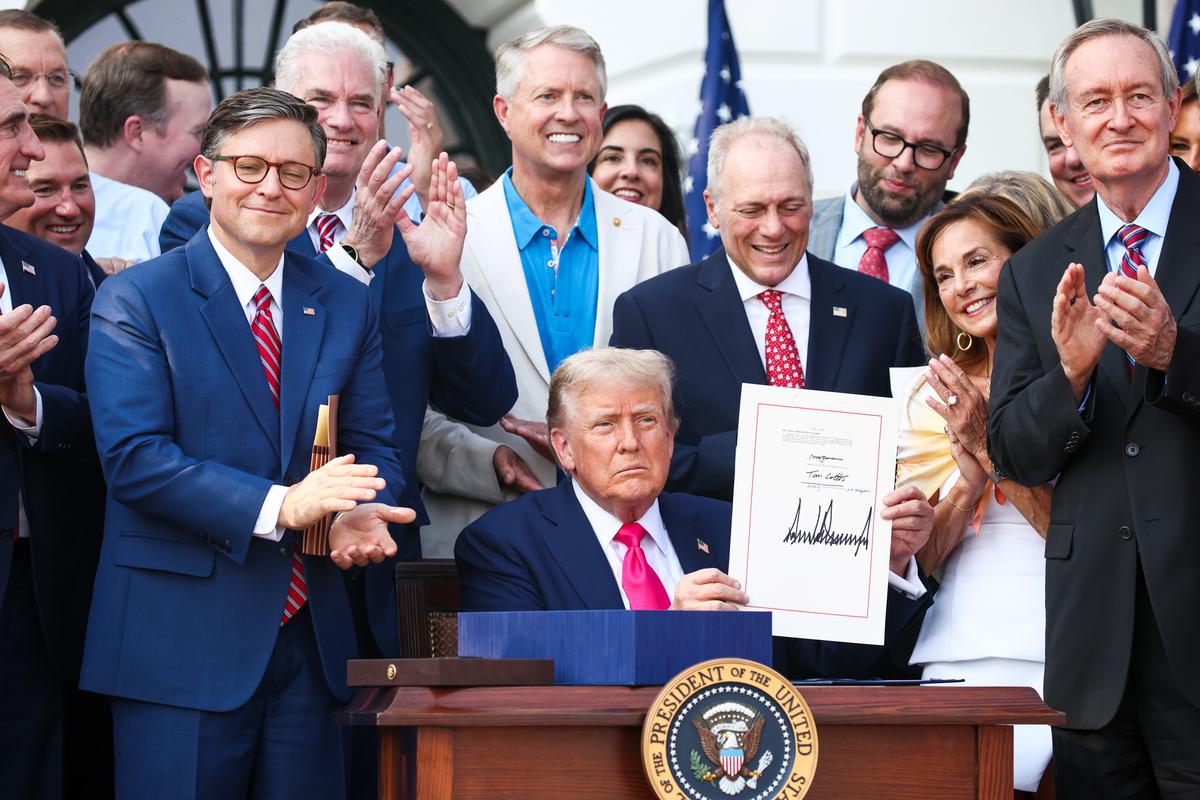 President Donald Trump, joined by Republican lawmakers, signs the One, Big Beautiful Bill Act into law during an Independence Day military family picnic on the South Lawn of the White House on July 4, 2025. (Samuel Corum/Getty Images)