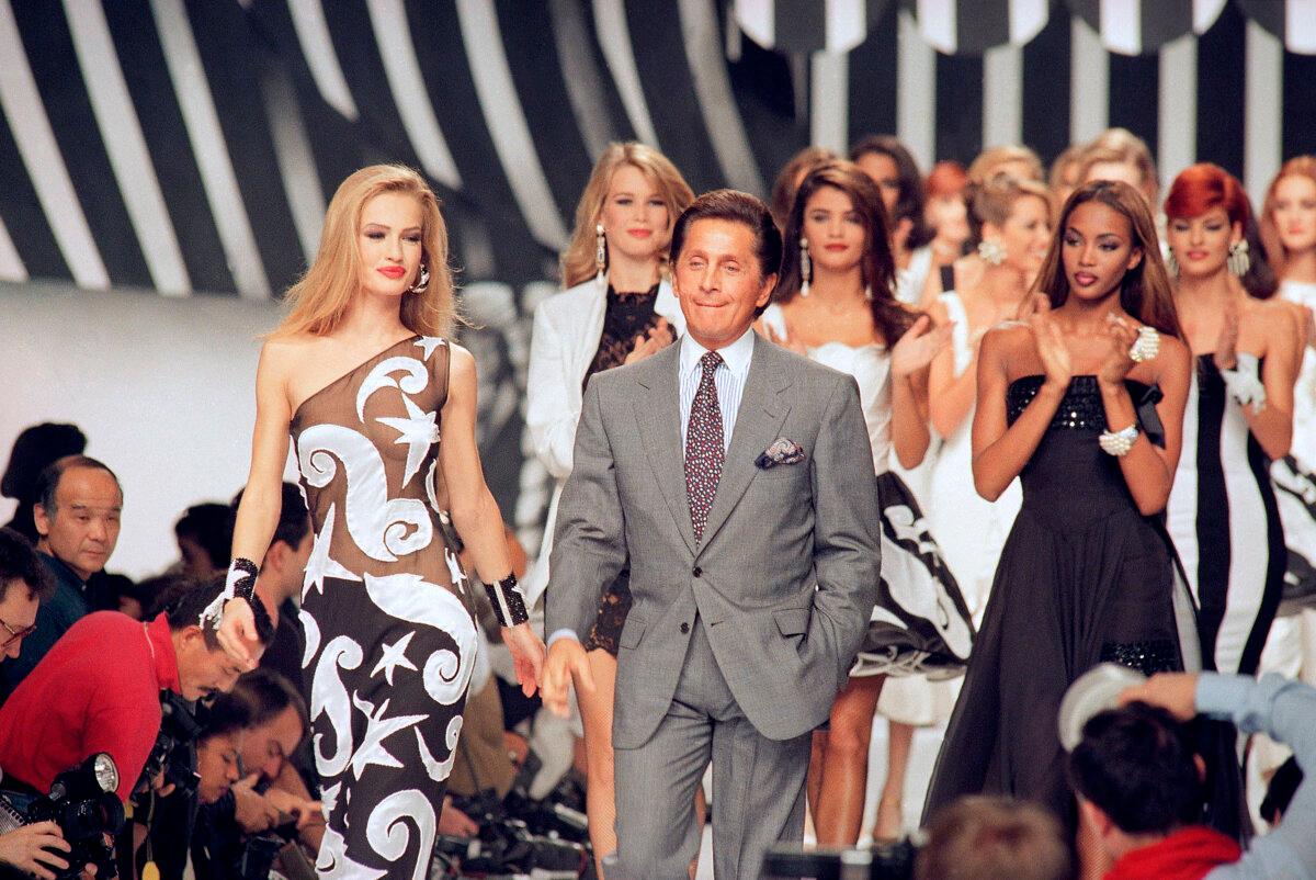 Italian fashion designer Valentino Garavani walks the catwalk with his models after a fashion show in Paris on Oct. 20, 1991. (Remy de la Mauviniere/AP Photo)