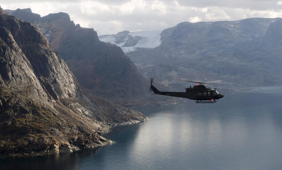 A Canadian military Griffon helicopter flies along the shoreline of Baffin Island in a file phot. (The Canadian Press/Adrian Wyld)