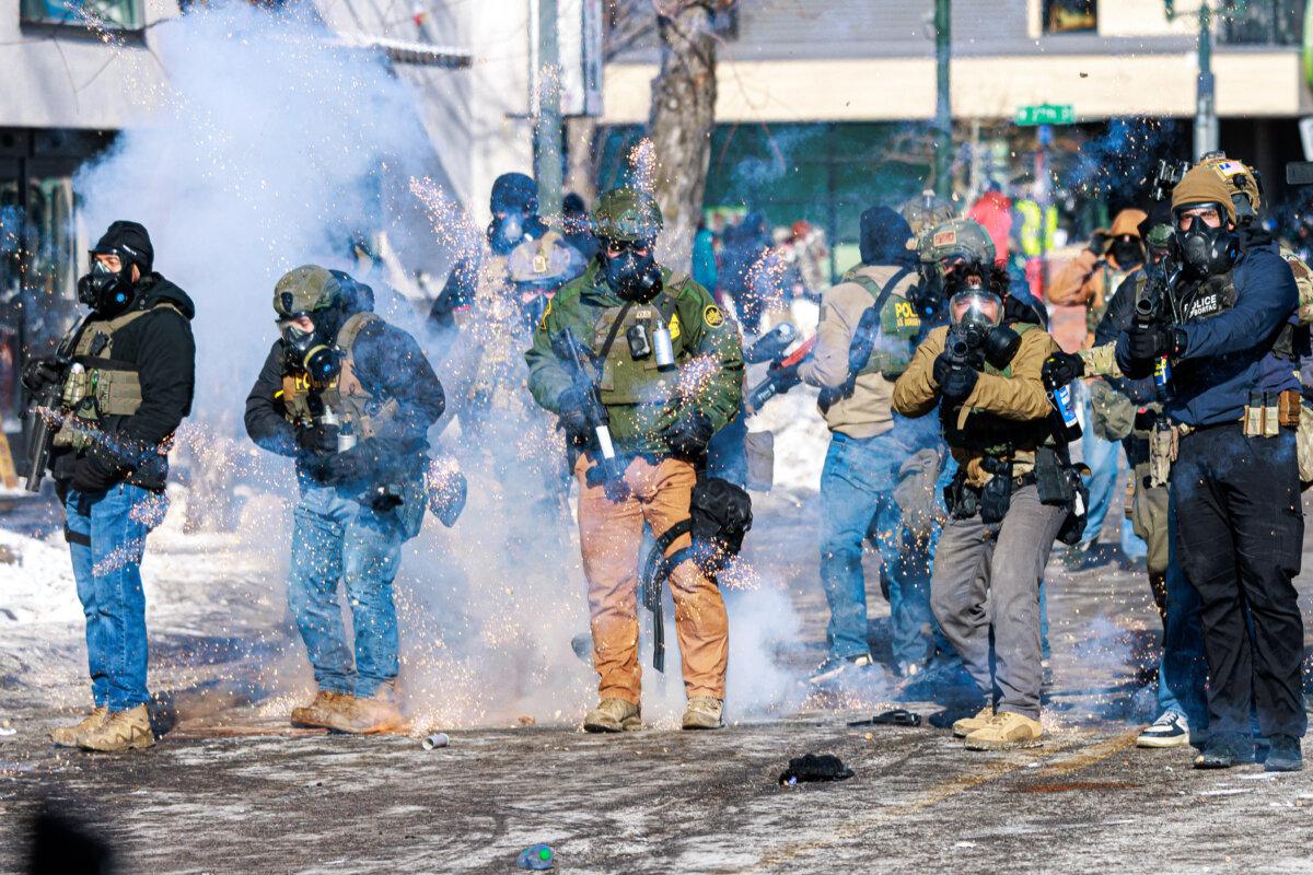 Federal agents fire flash-bang grenades as they advance toward protesters during clashes following the fatal shooting of a man by federal immigration agents earlier in the day in Minnesota, on Jan. 24, 2026. (Kerem Yucel/AFP via Getty Images)