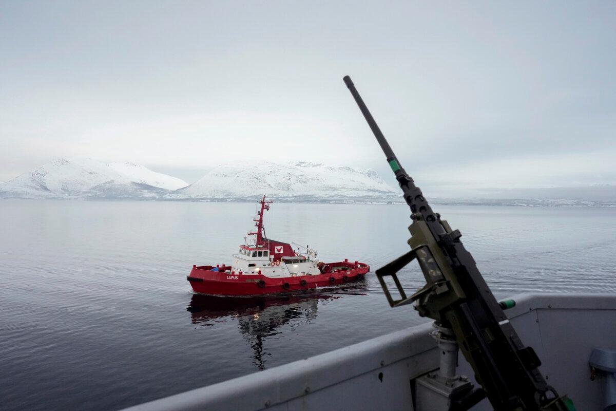 A tugboat sails alongside the French navy frigate Normandie before it docks during a patrol in a Norwegian fjord, north of the Arctic circle, on March 8, 2024. (AP Photo/Thibault Camus)