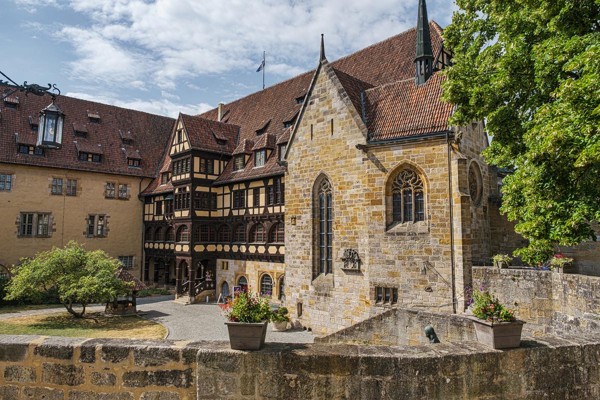 Veste Coburg’s current, 19th-century-built chapel replaced the original. Its stone-block construction features Gothic-style arch windows, a steep-pitched roof, and loophole (arrow slit) windows. Beside the chapel is an early classic German mortar-and-timber Fachwerkhaus-style dwelling. This building currently houses many museum items. (Harald Lueder/Shutterstock)