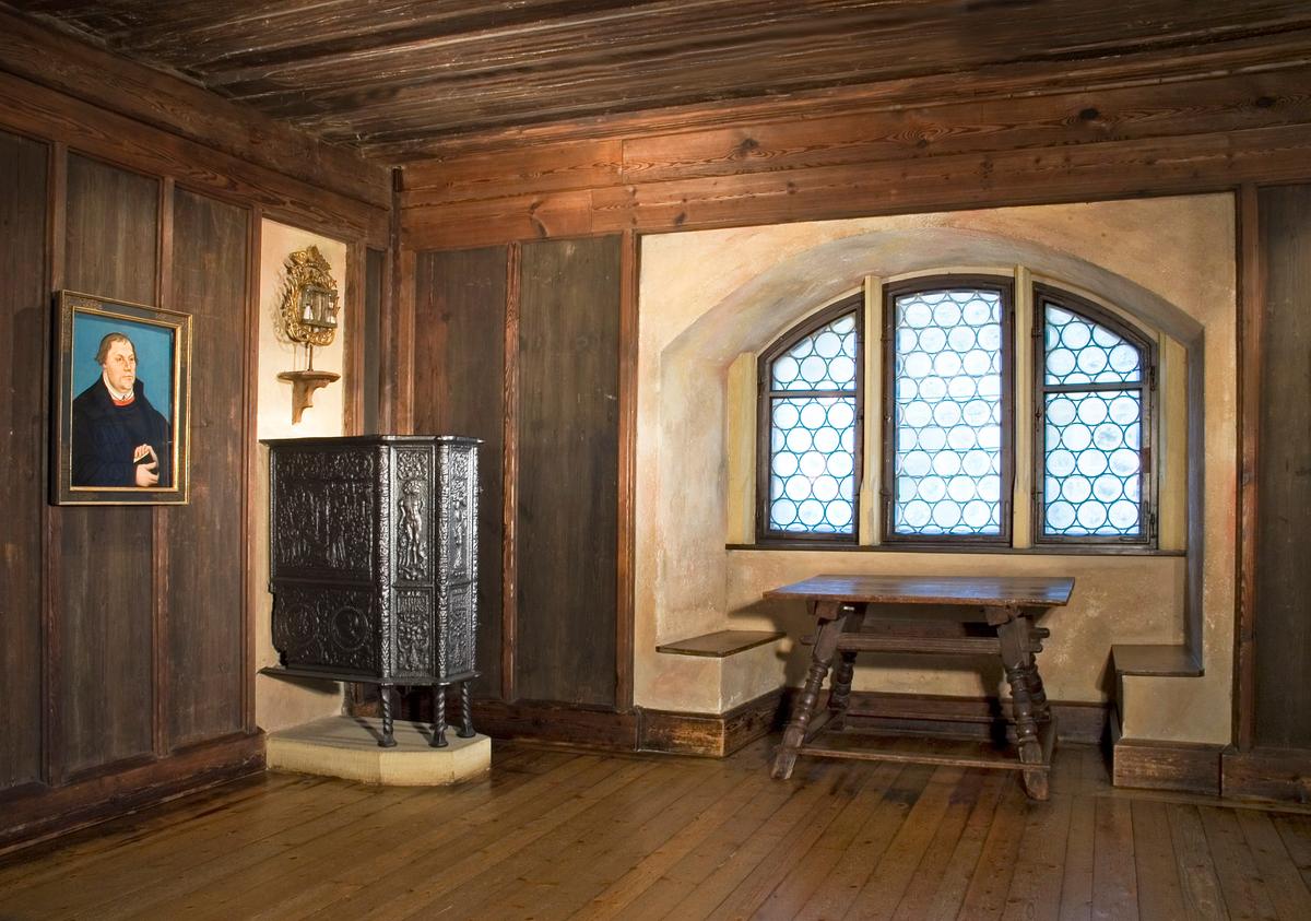 Veste Coburg served as a refuge in 1530 for Martin Luther, who famously spurred on the Protestant Reformation. In this room, he translated parts of the Bible into German so that laypeople could read it, not just Catholic priests or bishops. The simple table that Luther used is on display in this sparse room, along with an intricately carved headboard. The portrait of Luther that hangs on the wall was painted by 16th-century artist Lucas Cranach the Elder. (<a title="User:Veste Coburg" href="https://commons.wikimedia.org/wiki/User:Veste_Coburg">Kunstsammlungen der Veste Coburg</a>/ <a title="Category:CC-BY-SA-4.0" href="https://commons.wikimedia.org/wiki/Category:CC-BY-SA-4.0">CC-BY-SA-4.0</a>)