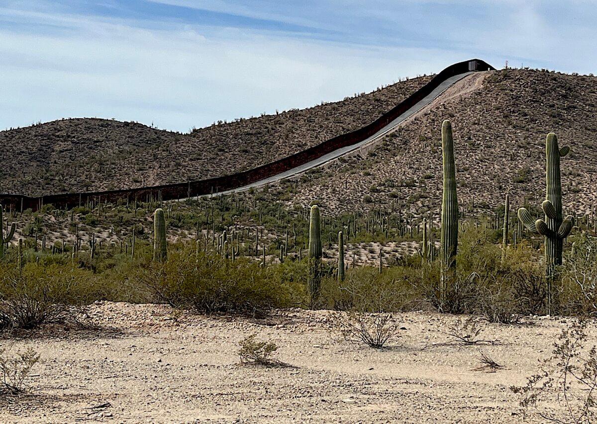 Security barrier fencing trails into the mountains near the commercial land port of entry in Lukeville, Ariz., on Jan. 22, 2026. (Allan Stein/The Epoch Times)