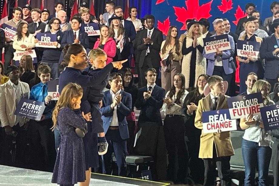 Anaida Poilievre points out her husband, Conservative Leader Pierre Poilievre, to their children as he walks toward the stage at the Conservative Party's convention at the BMO Centre in Calgary on Jan. 30, 2026. (Omid Ghoreishi/The Epoch Times)