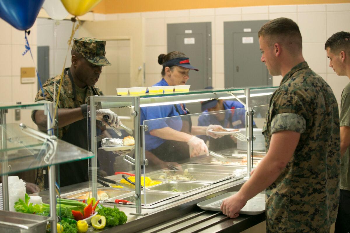 Chow hall employees and a Marine officer serve food to Marines and sailors during the 241st Navy Birthday Meal held at Marine Corps Air Station New River, N.C., on Oct. 13, 2016. (Cpl. Melodie Snarr/U.S. Marine Corps via DVIDS)