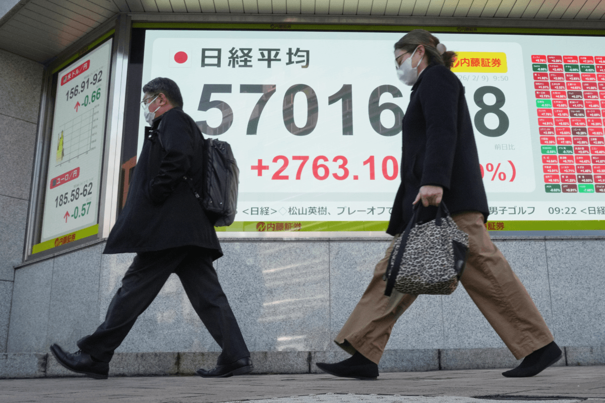 People walk past an electronic stock board showing Japan's Nikkei index at a securities firm in Tokyo on Feb. 9, 2026. (Eugene Hoshiko/AP Photo)