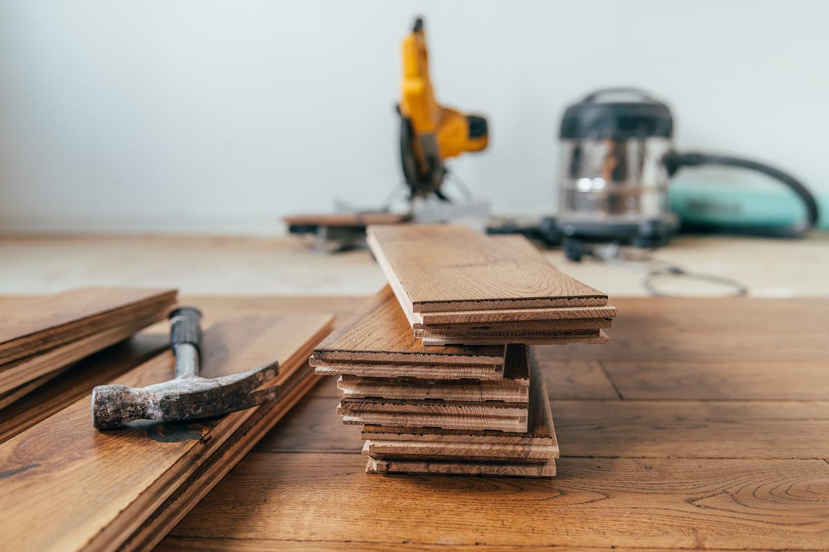 Engineered hardwood features a real wood veneer over a stable core, offering the appearance of traditional wood at a lower cost. (Anna Mente/Shutterstock)