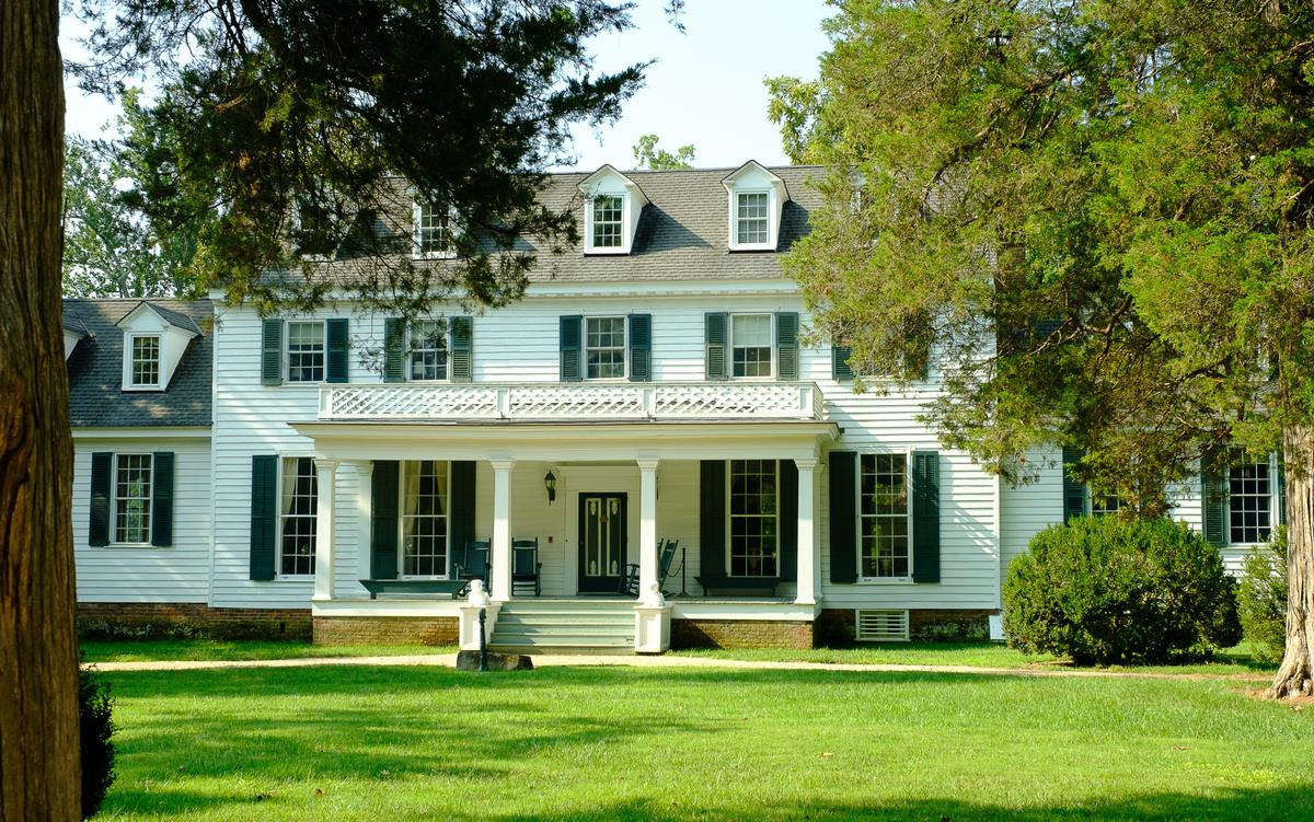 Decorating the otherwise plain exterior of the Sherwood Forest home is a Greek Revival-style portico that features square columns topped with Doric capitals. The portico's entablature is decorated with lattice, an adornment featured in one of designer Andrew Jackson Downing’s (1815–1852) widely influential books on Hudson River Valley houses. Flanking the stairs on wooden pedestals are 19th-century cast-iron and painted sculptures of Chesapeake setter dogs. (Sherwood Forest Plantation Foundation)