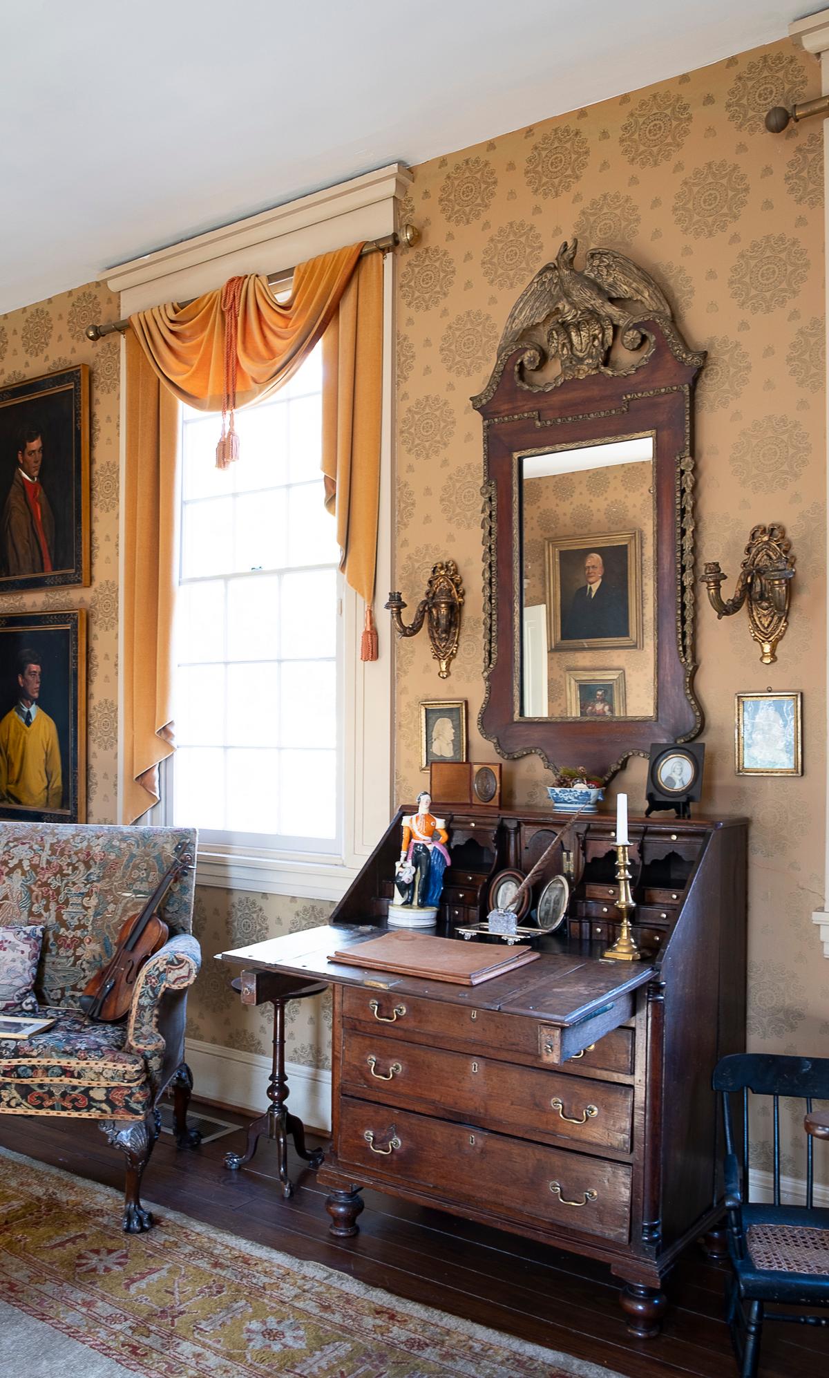 Hanging over the Tyler family's Georgian desk, in what is referred to as the Gray Room, is a carved and gilded wood mirror featuring a Georgian, heraldic eagle crest. The mirror is flanked by ornamental gilt-metal candelabra sconces. (Sherwood Forest Plantation Foundation)