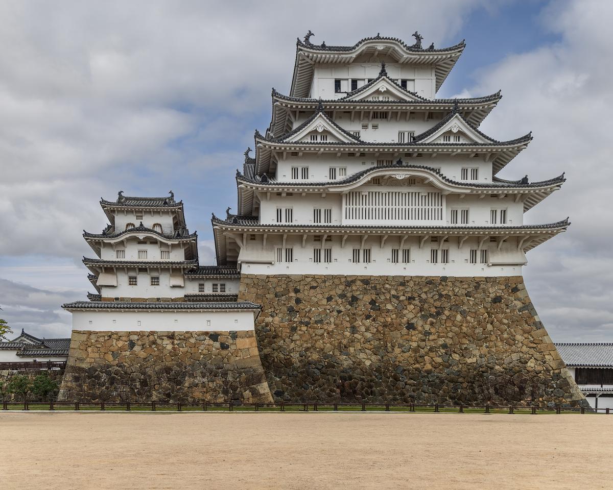 The main keep is flanked by small yagura turrets, defensive watchtowers that protect corners and connected walls, featuring narrow slits for firing arrows or guns. Curved stone walls strengthen the base and impede attackers, while multilayered roofs and angled eaves protect against rain and assault. Fire-resistant plaster and sturdy timber framing support the multistory structure. Together, these elements reflect the Edo-period integration of military efficiency and architectural design. (Artyart/Shutterstock)