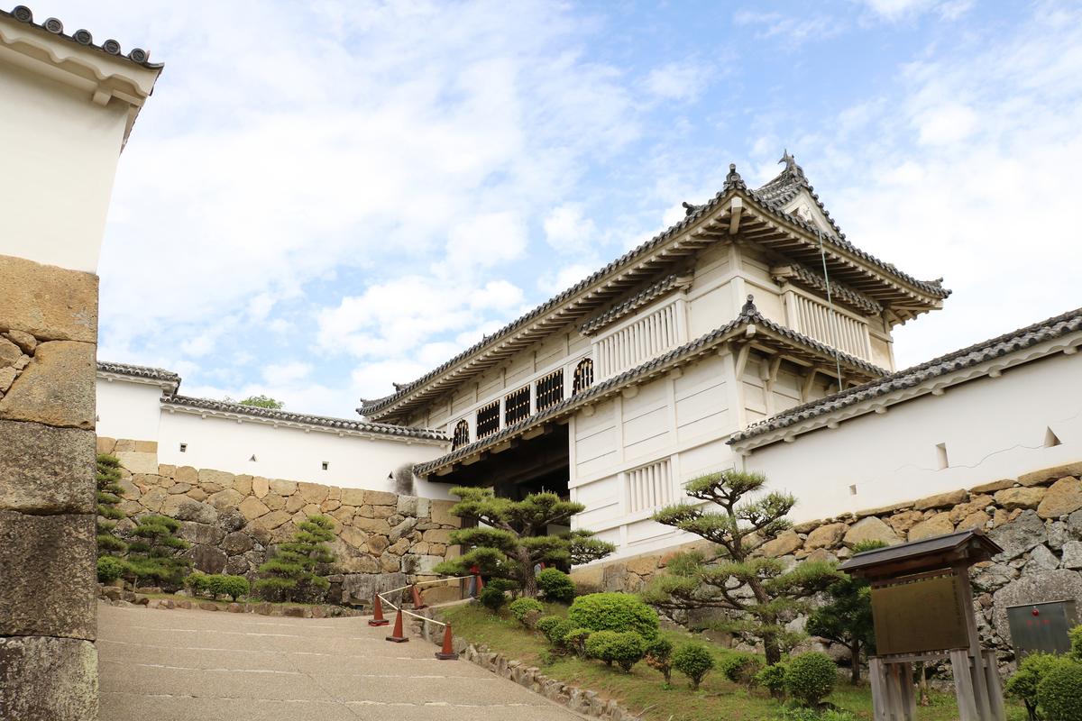 Himeji Castle's largest gate, Hishi-no-Mon (Diamond Gate), rises in bright white above stone walls leading to the second compound. The structure is a yaguramon-style gate, meaning that it has a defensive tower built above the passageway. The structure combines defensive stone steps and flanking walls with interlocking eaves. (L.W.Wizard/Shutterstock)