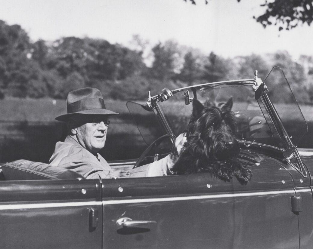 Franklin D. Roosevelt drives around Hyde Park, N.Y., with his dog, Fala, in the front seat. Fala was popular enough to regularly receive letters from the public. (Library of Congress)