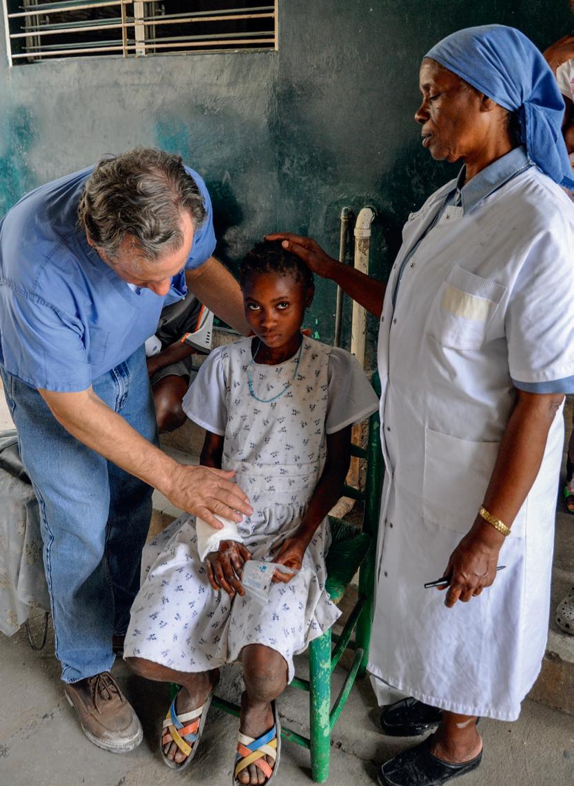 The doctor in Haiti giving medical care to a patient who was crushed by a fallen structure during the major earthquake in 2010. (Courtesy of Dr. Chauncey Crandall)