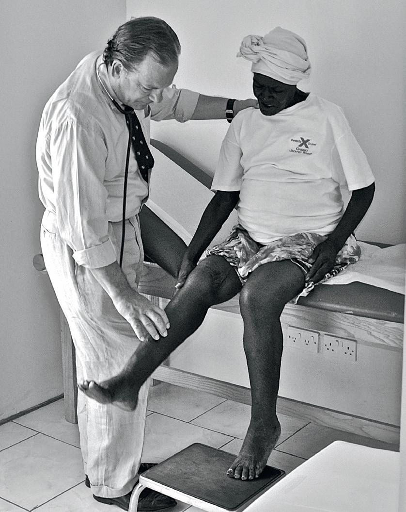 The doctor has been on many medical missionary trips to help treat the less fortunate. Here, he prays for and treats a woman with heart failure in the British West Indies. (Courtesy of Dr. Chauncey Crandall)