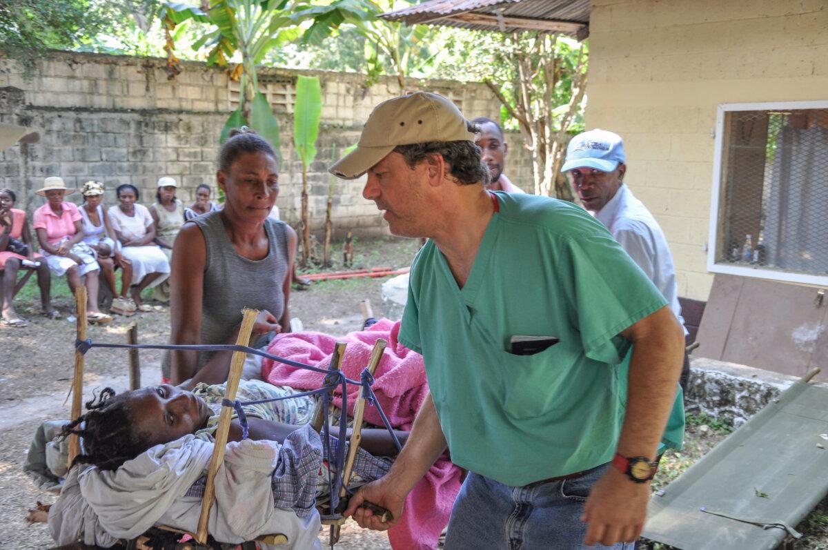 Crandall in Haiti giving medical care to a patient who was crushed by a fallen structure during the major earthquake in 2010. (Courtesy of Dr. Chauncey Crandall)