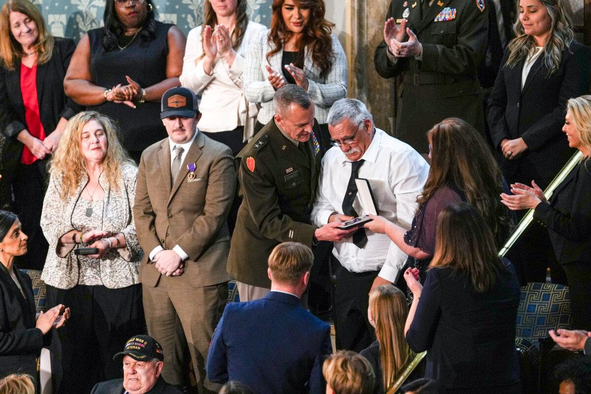 Evalea and Gary Beckstrom, parents of Sarah Beckstrom, the West Virginia National Guard member who was killed in an ambush in Washington, receive the Purple Heart at President Donald Trump's first State of the Union address during his second presidential term, in the House Chamber on Capitol Hill in Washington on Feb. 24, 2026. (Madalina Kilroy/The Epoch Times)