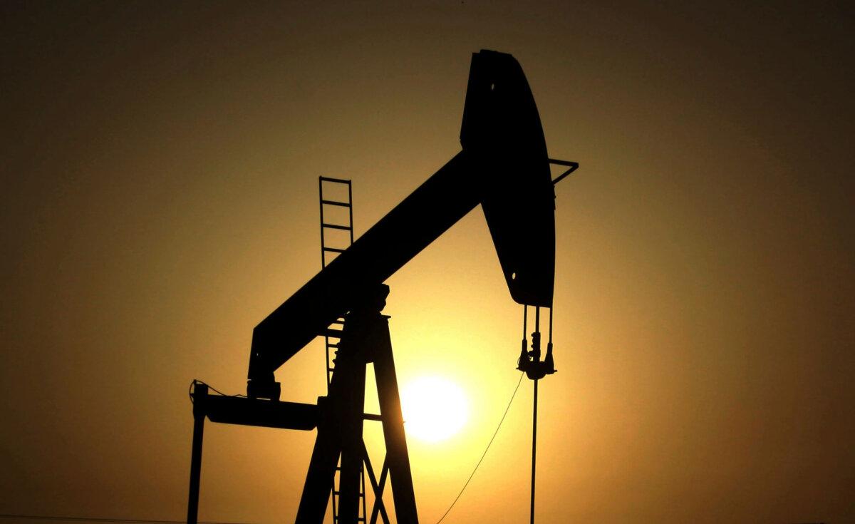 The sun sets behind an oil pump in the desert oil fields of Sakhir, Bahrain, on June 8, 2011. (Hasan Jamali/AP Photo)