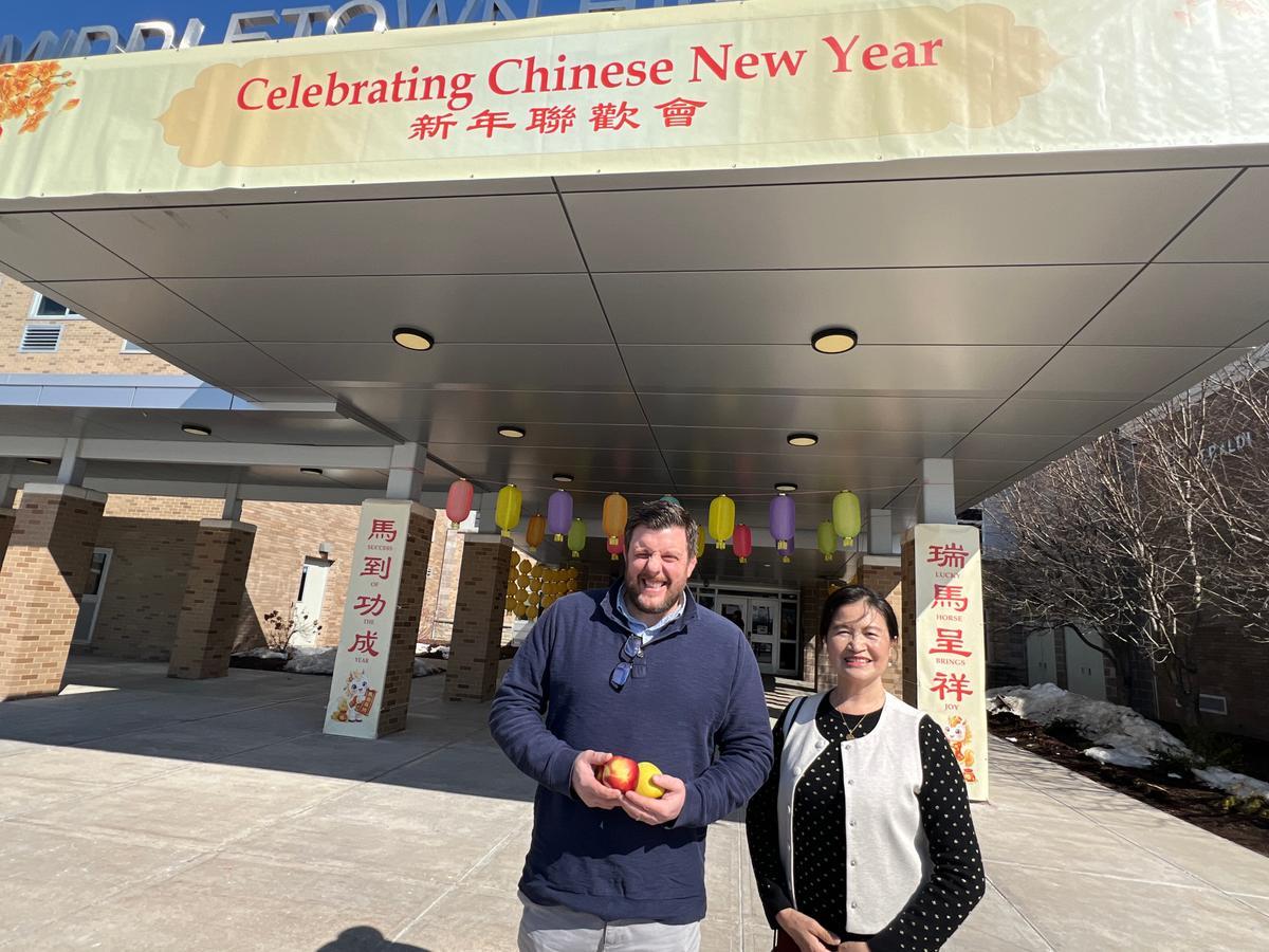 Middletown High School Principal William Donohue (L) and Mount Hope Chinese Association president Mela Wu (R) outside of Middletown High School in Middletown, N.Y., on Feb. 28, 2026. (Dai Bing/The Epoch Times)