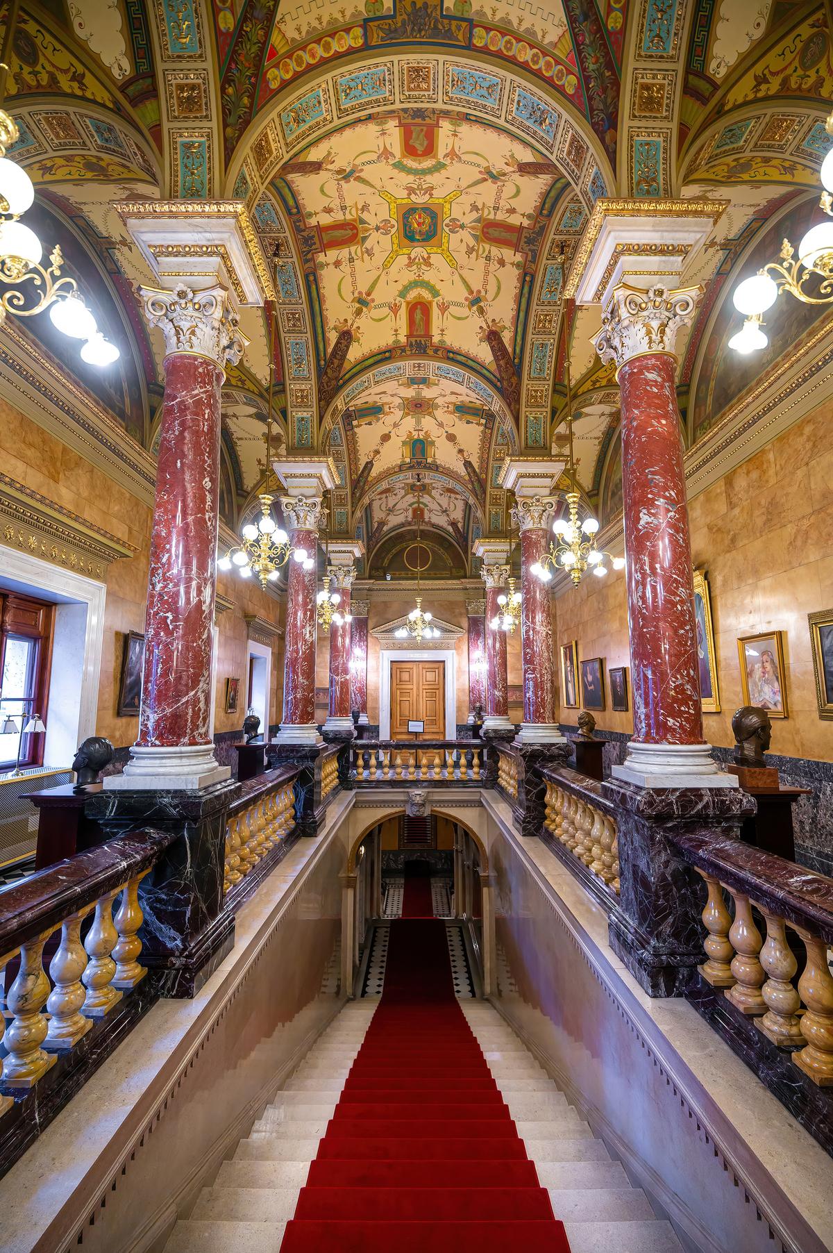 Leading from the outside carriage ramp to the inside of the Hungarian State Opera House is what is deemed the Royal Staircase, because the entryway enables actual royalty to enter the venue discreetly. Eight red marble columns on snow-white, Carrara-marble bases sit atop greenish Florentine-marble pedestals. Florentine marble railings are punctuated with yellow Siena-marble balustrades. Gracing the ceiling are paintings of mythological creatures. (Mitzo/Shutterstock)
