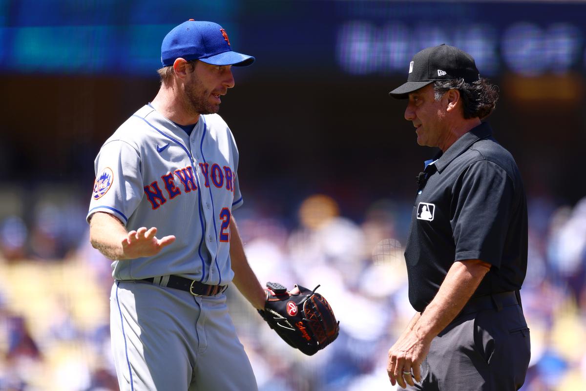 Max Scherzer (L) of the New York Mets argues with umpire Phil Cuzzi during a game against the Los Angeles Dodgers at Dodger Stadium in Los Angeles on April 19, 2023. (Katelyn Mulcahy/Getty Images)