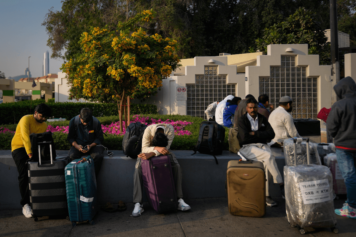 Passengers stranded by the closure of Dubai International Airport await assistance in the airport parking lot in Dubai, United Arab Emirates, on March 1, 2026. (Altaf Qadri/AP)