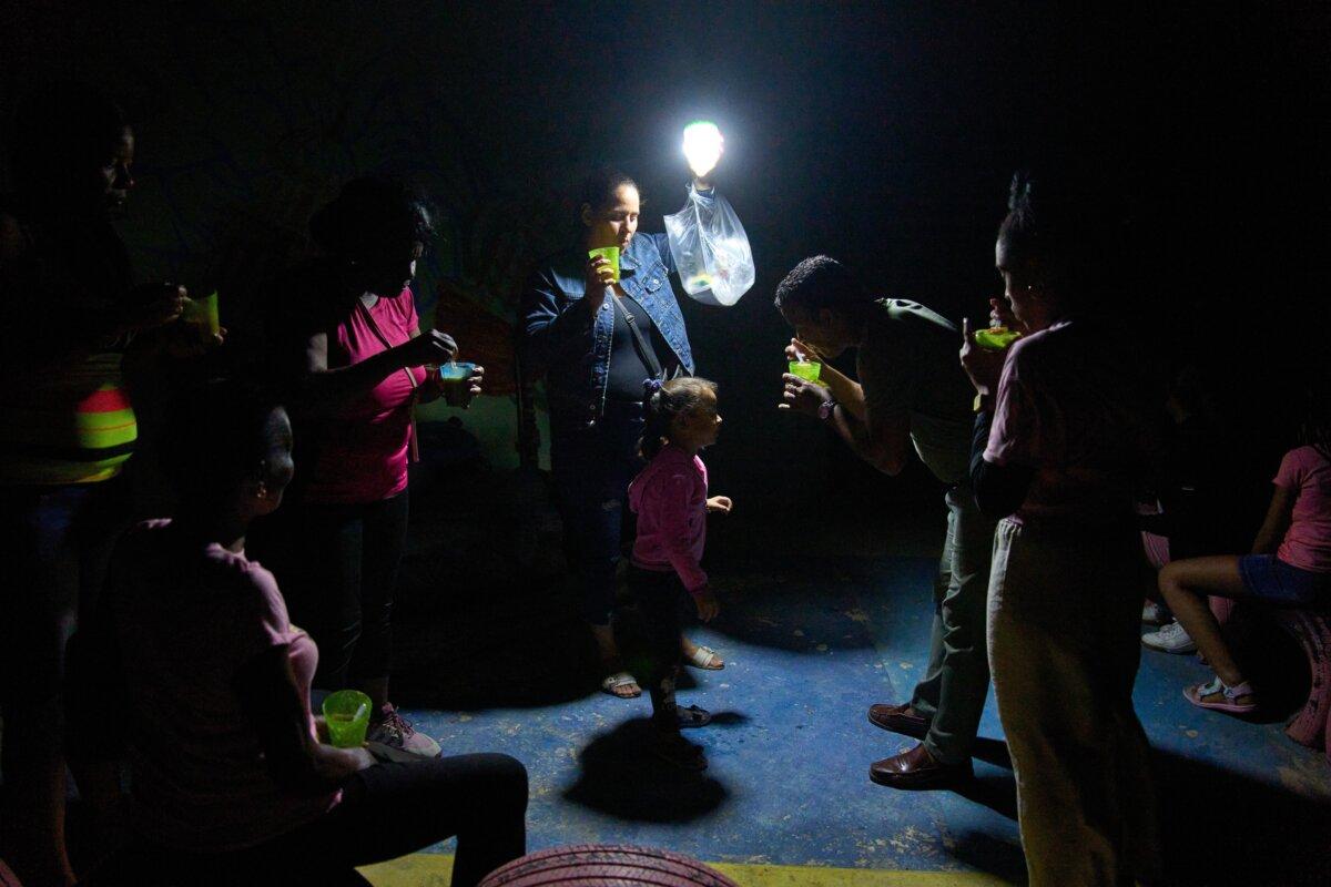 People eat soup from cups outside during a blackout caused by power outages in Havana, Cuba, on March 4, 2026. (Ramon Espinosa, AP)