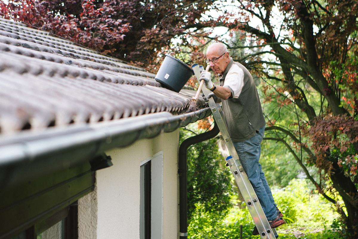 Unclogging the gutters will ensure proper water drainage and prevent damage to roofing, siding, and foundations. (fotografixx/Getty Images)