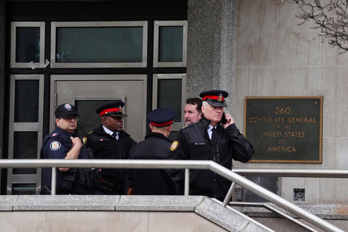 Toronto police officers investigate outside the U.S. Consulate in Toronto after shots were fired at the building on March 10, 2026. (The Canadian Press via AP/Frank Gunn)